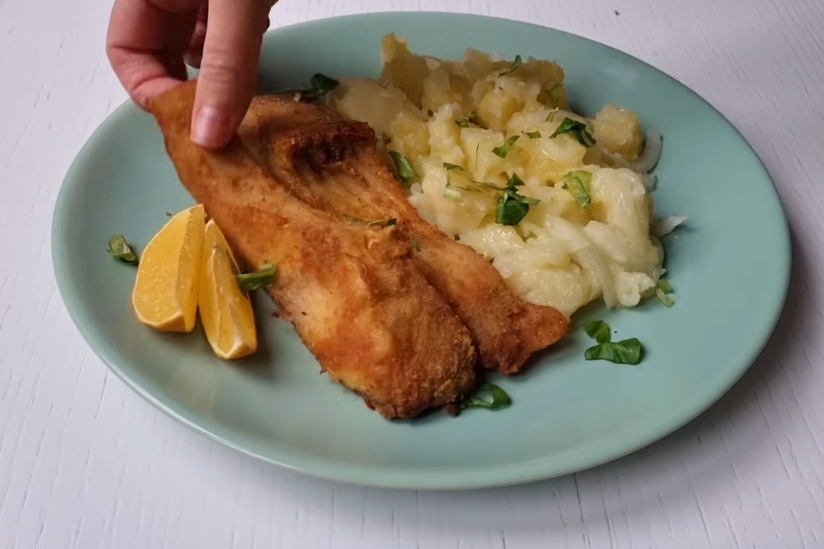 prikaz serviranja šarana iz rerne sa restovanim krompirom i limunom na tanjir