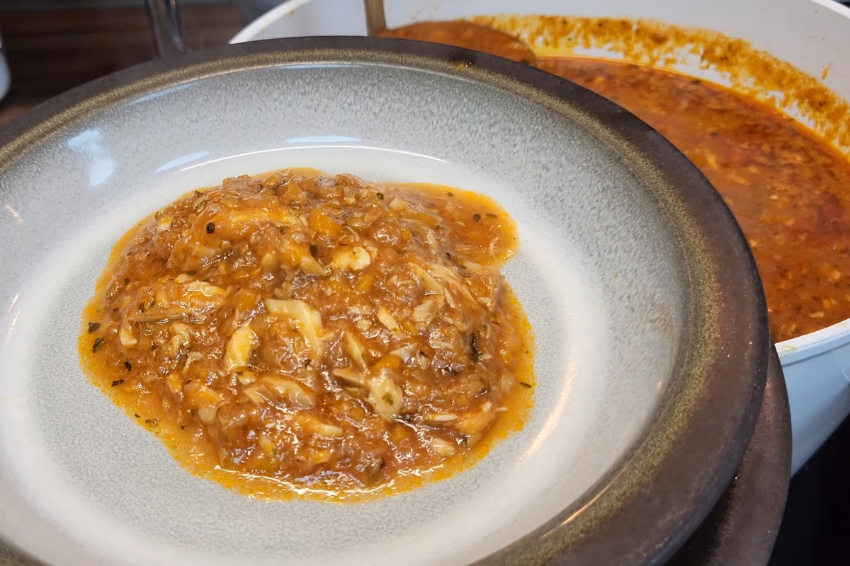 osoba sipa riblju čorbu u tanjir